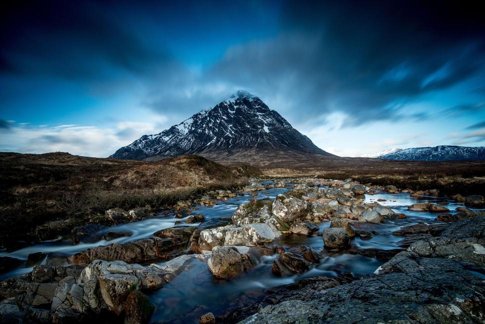 Free Image of Snow-capped mountain under cloudy sky with stream 