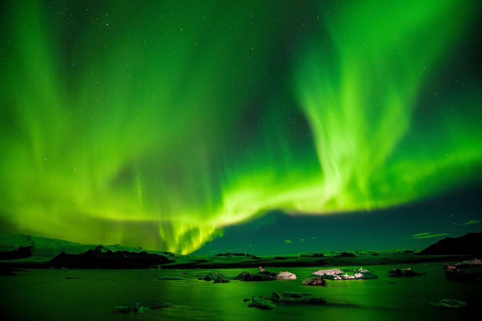 Free Image of Vibrant green aurora borealis over icy Arctic waters. 