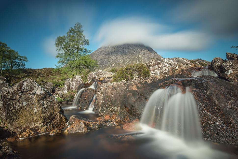 Free Image of Majestic waterfall cascades with mountain backdrop 