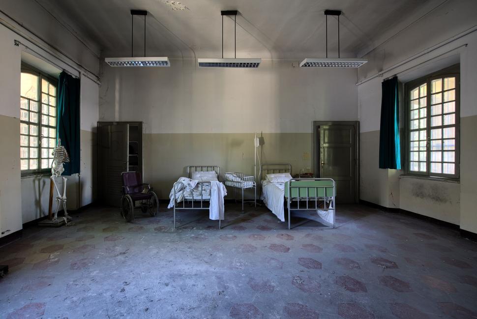 Free Image of Abandoned hospital room with beds and wheelchair 