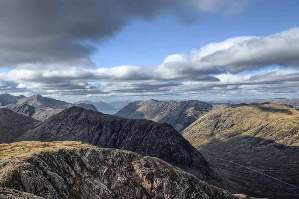 Free Image of Panoramic view of mountainous landscape under cloudy sky 