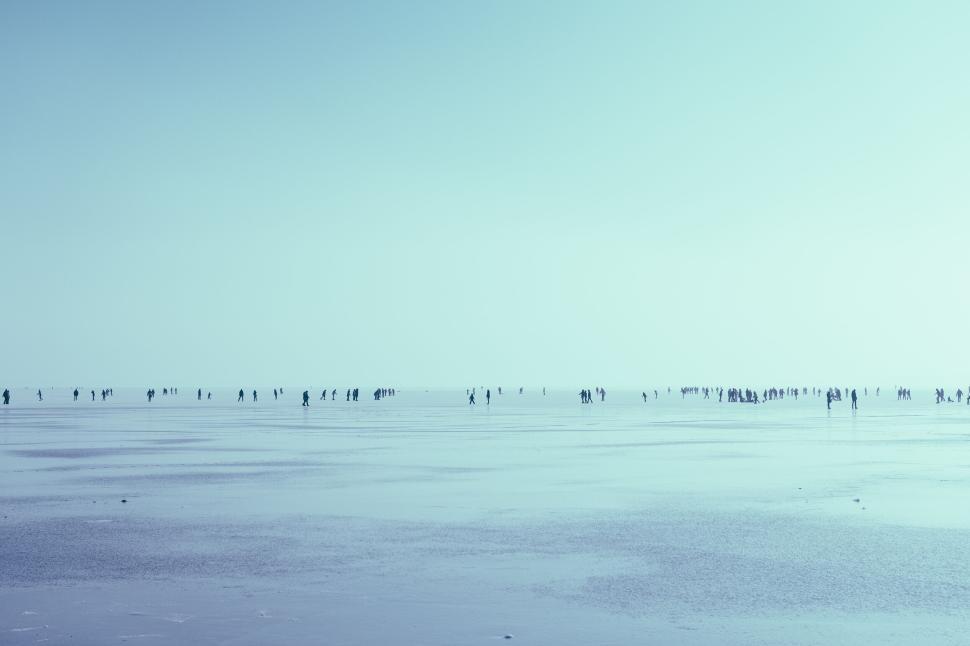 Free Image of Wide expanse of beach with tiny figures in the distance 