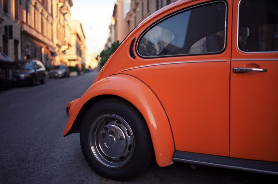 Free Image of Classic orange vintage car parked on urban street 