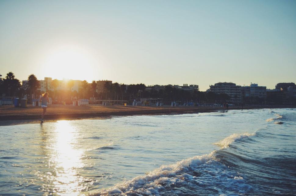 Free Image of Sunset beach scene with calm waves and gentle sunlight. 