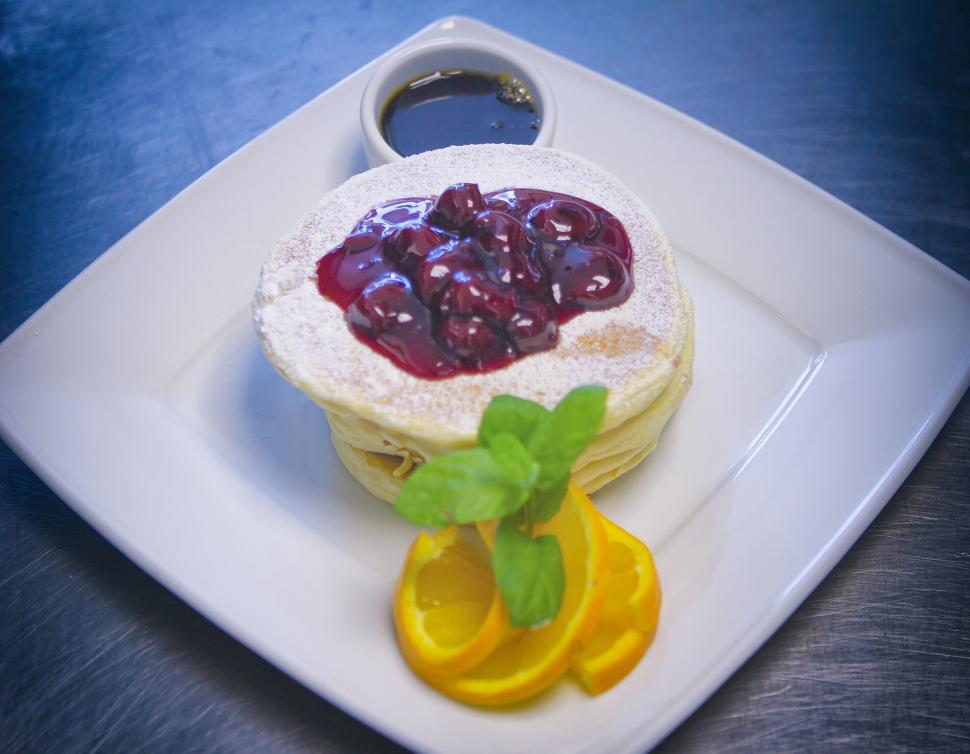 Free Image of Stack of pancakes topped with berry sauce and mint. 