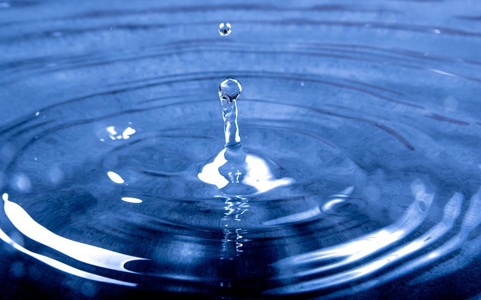 Free Image of Water droplets creating ripples on a blue surface 