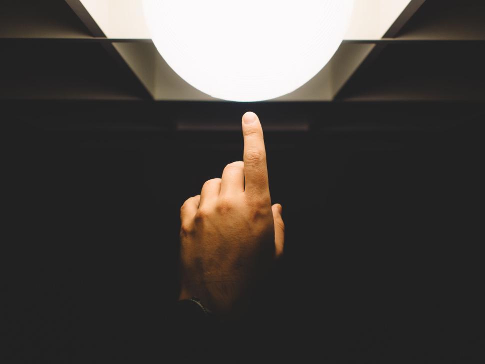 Free Image of Hand reaching out to touch a bright illuminated sphere 