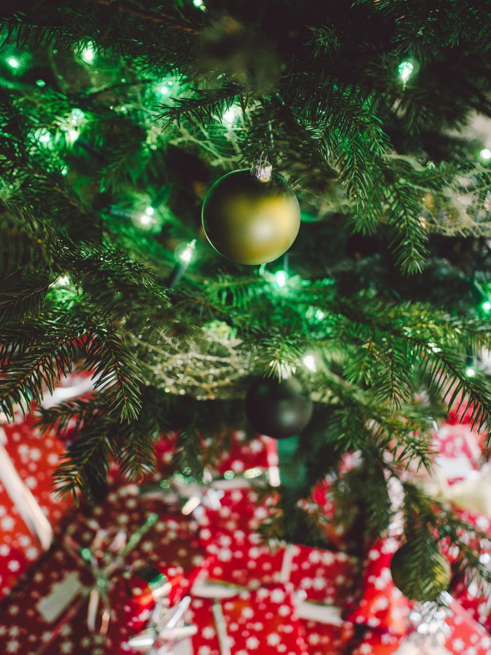Free Image of Christmas tree with bright lights and gifts underneath. 