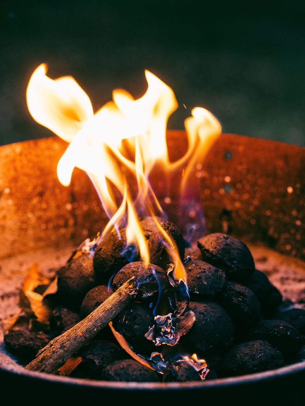 Free Image of Fire pit with brightly glowing flames in the evening. 