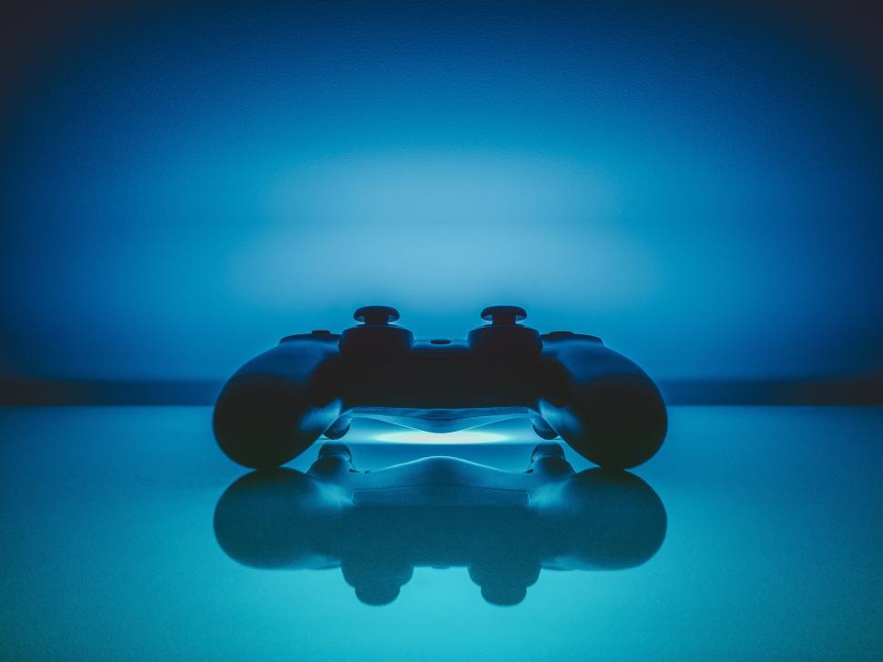 Free Image of Silhouette of a gaming controller with blue backlight. 