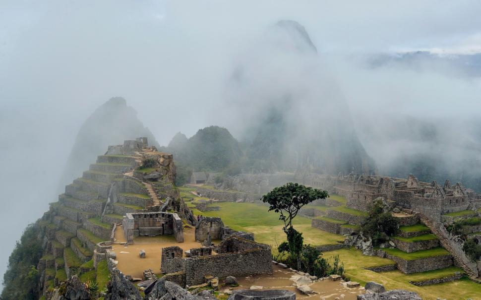 Free Image of Machu Picchu ancient ruins shrouded in misty clouds 
