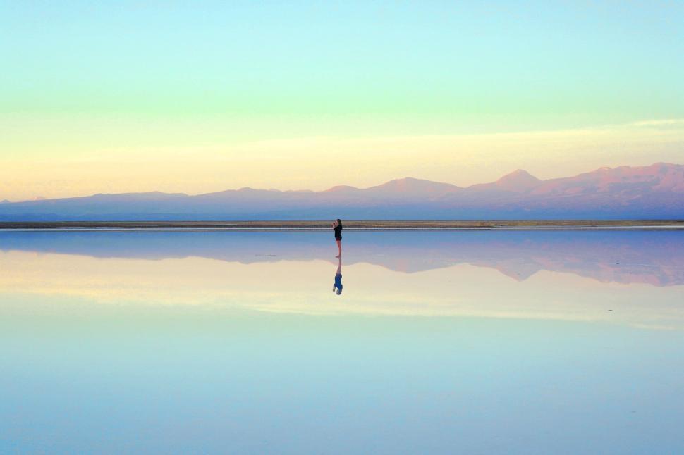 Free Image of Person standing on reflective surface in serene landscape 