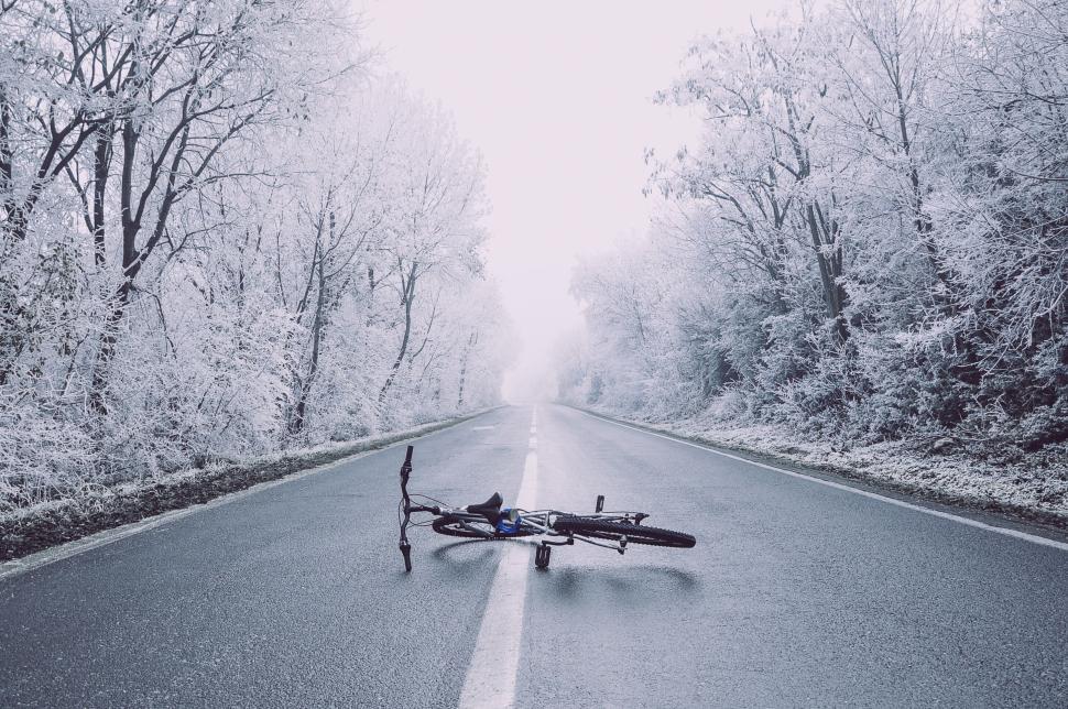 Free Image of Abandoned bicycle on an empty snow-covered road 