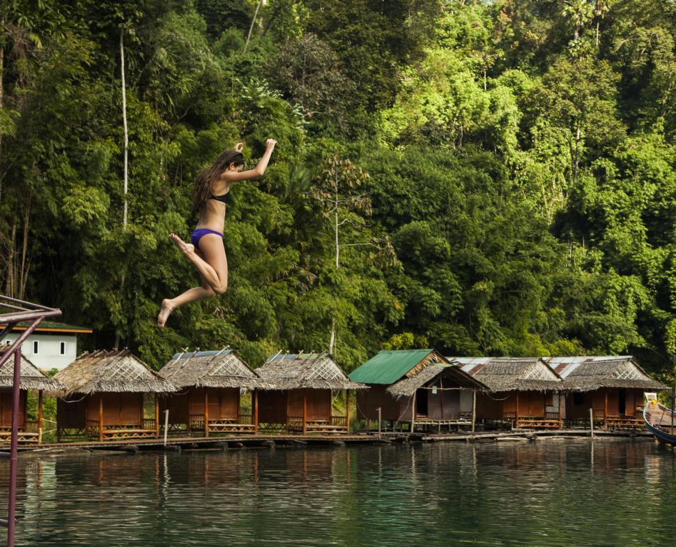 Free Image of Woman Jumping into Water Against Jungle Backdrop 
