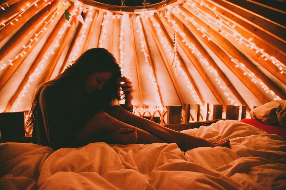 Free Image of Person inside dimly lit cozy room with string lights. 