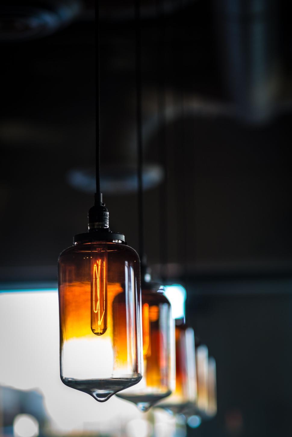 Free Image of Vintage hanging lights illuminating in the dark space. 