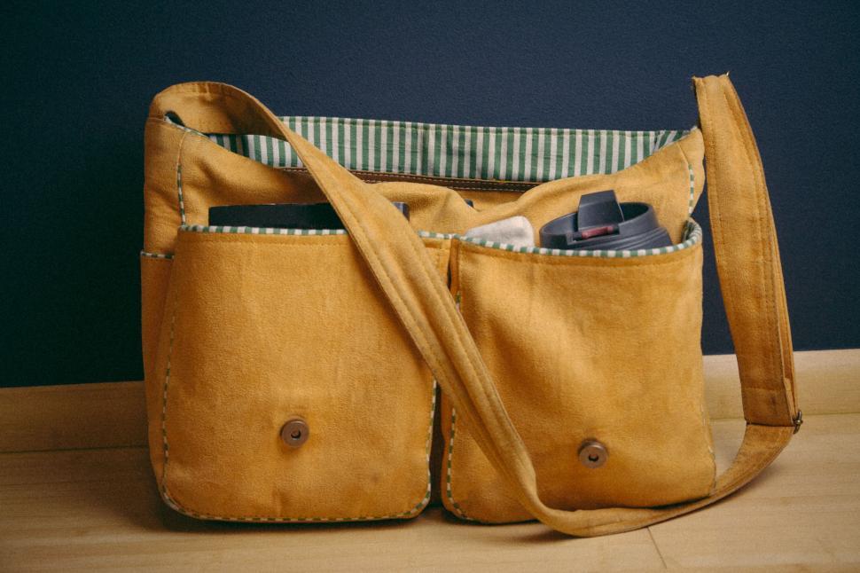 Free Image of Yellow fabric shoulder bag with striped interior lining. 