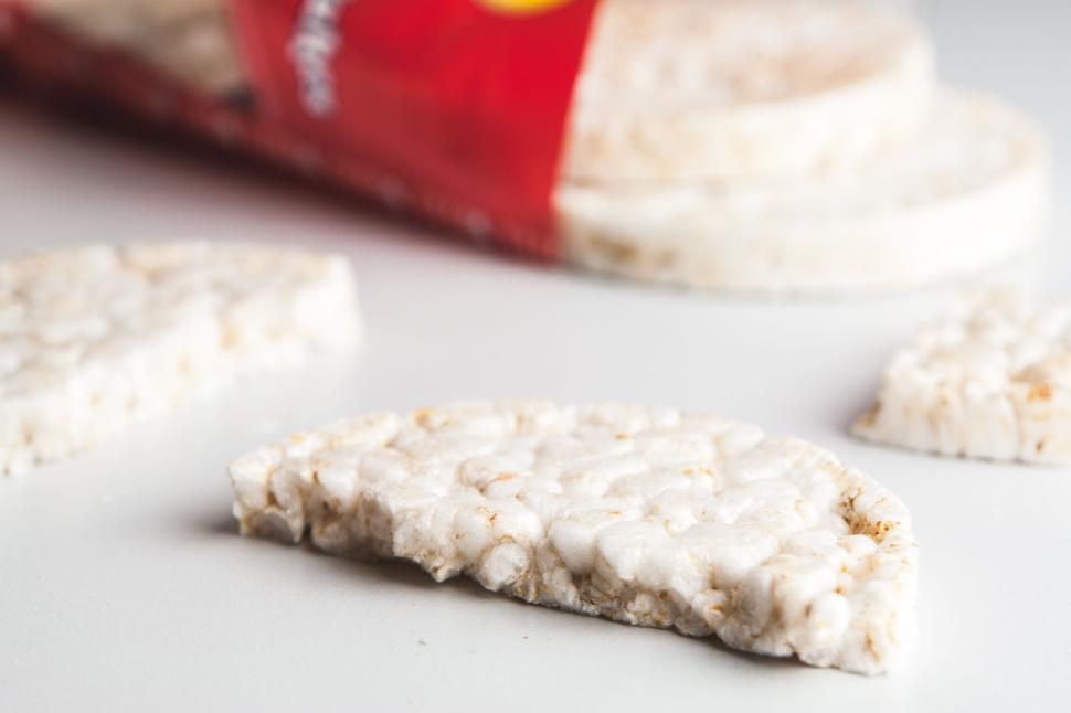Free Image of Half-eaten puffed rice cake laying on a white surface. 