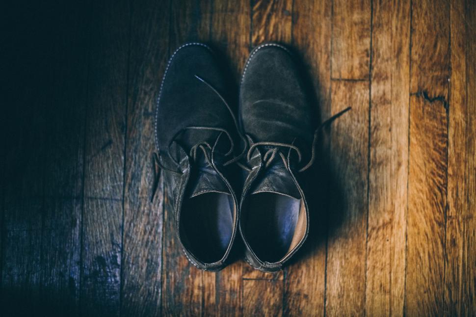 Free Image of Brown suede shoes placed neatly on wooden floor. 