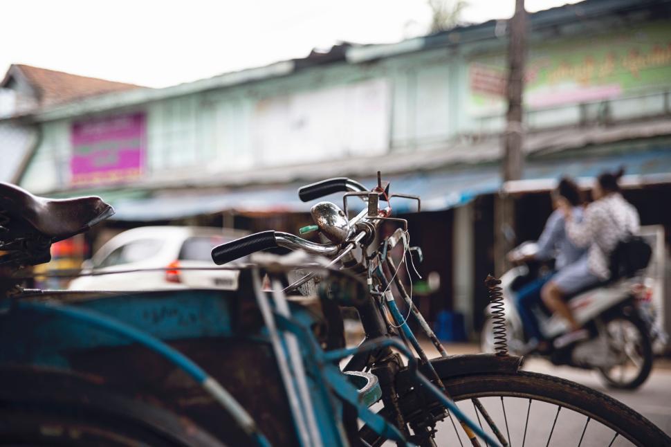 Free Image of Bicycle parked on a street with blurred background. 