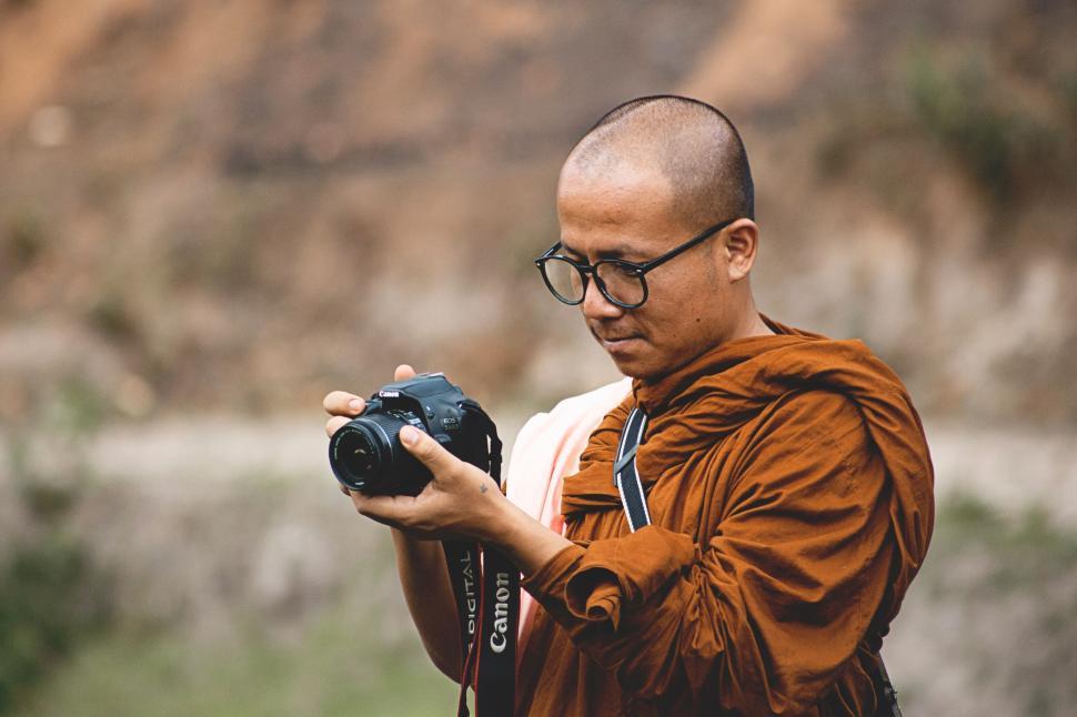 Free Image of Person holding a camera in brown clothing in nature 