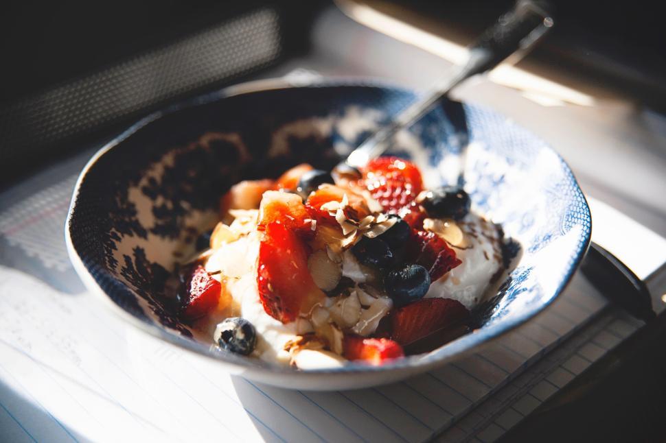 Free Image of A bowl of yogurt topped with diverse fresh berries. 