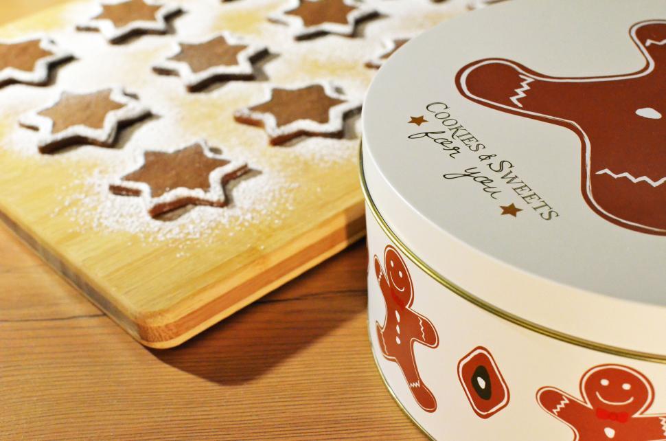 Free Image of Gingerbread and star cookies in a tin on wooden table. 