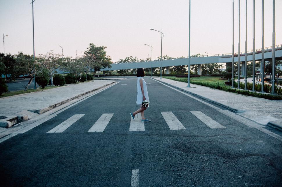 Free Image of Person crossing an empty pedestrian zebra-crossing. 