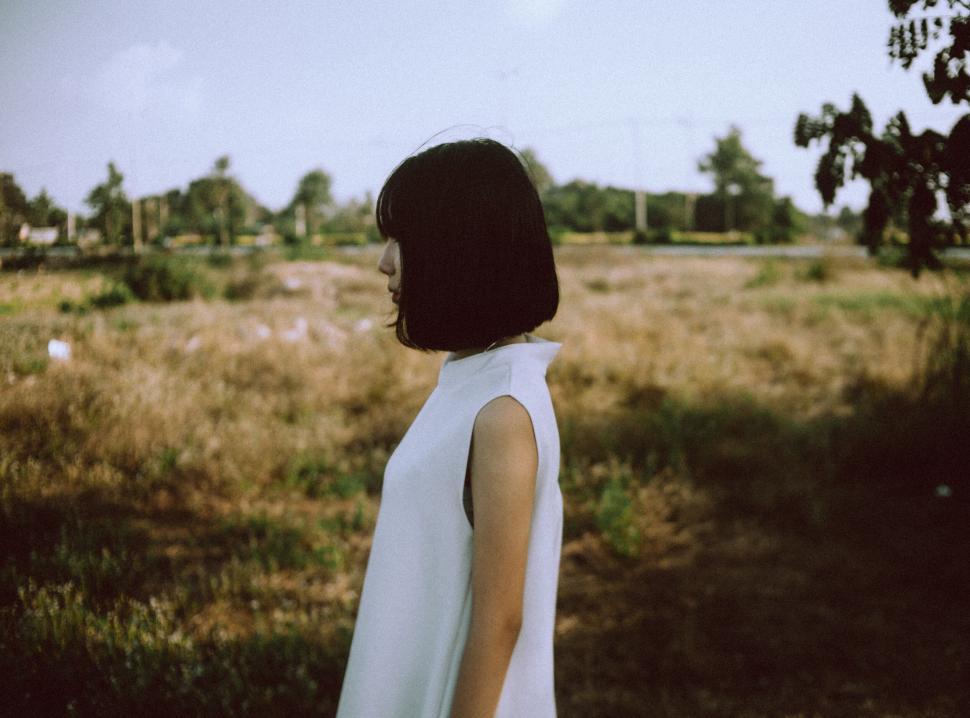 Free Image of Person in white outfit standing in a grassy field. 