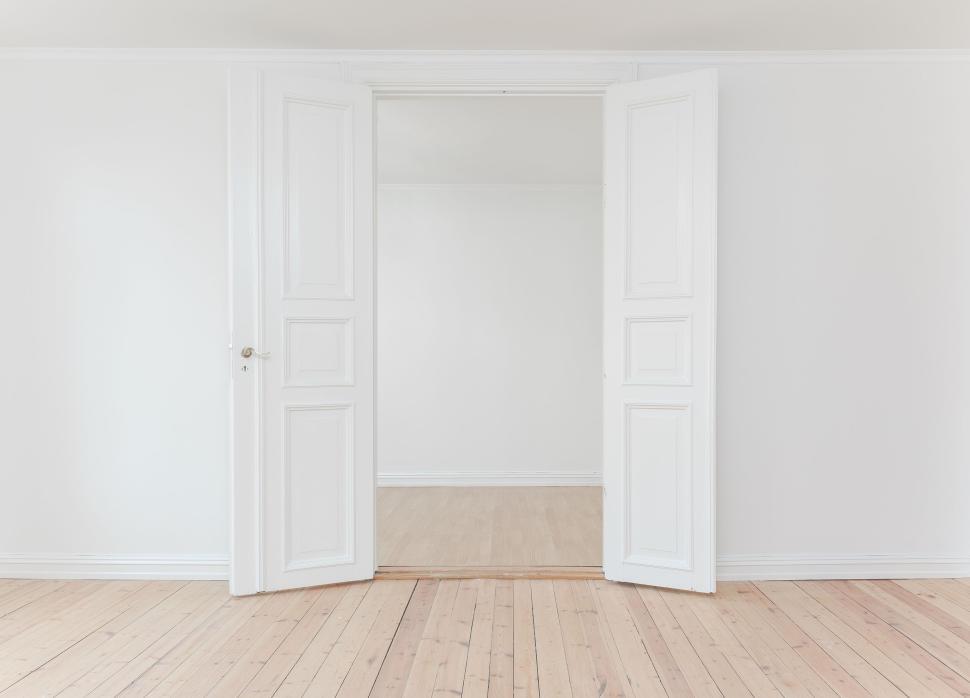 Free Image of Bright white room with open double doors and wooden floor 