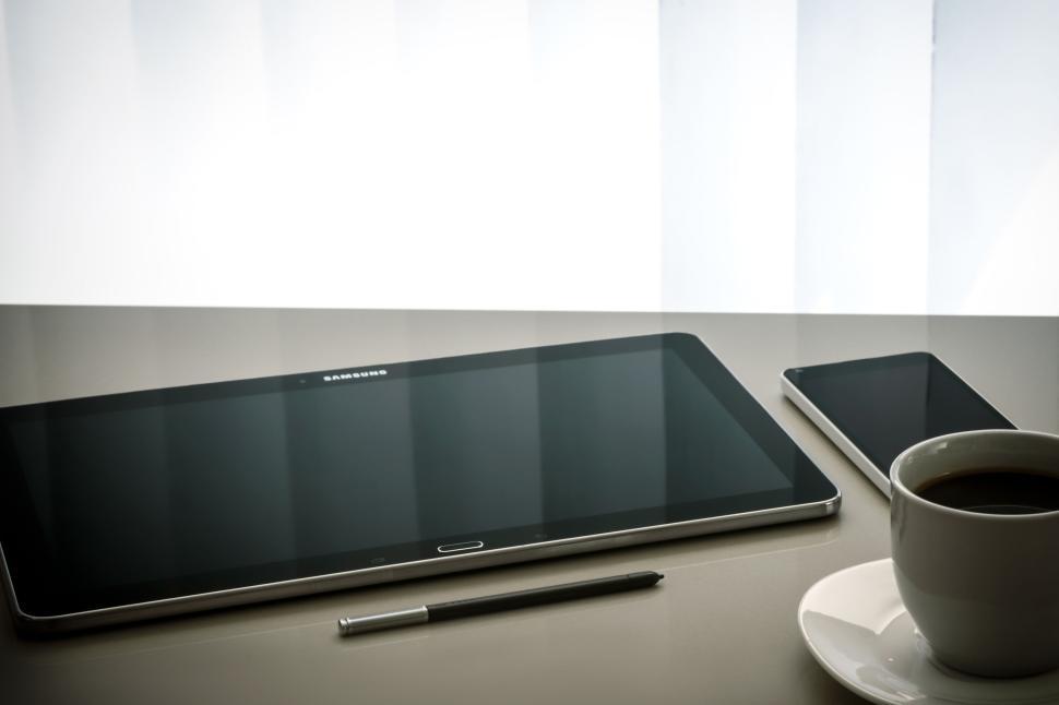 Free Image of Tablet, smartphone, stylus, and coffee cup on table 