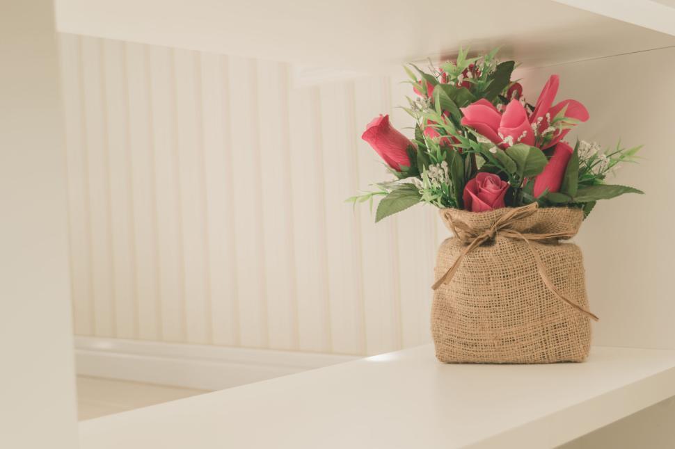 Free Image of Bouquet of pink flowers in burlap sack on shelf 