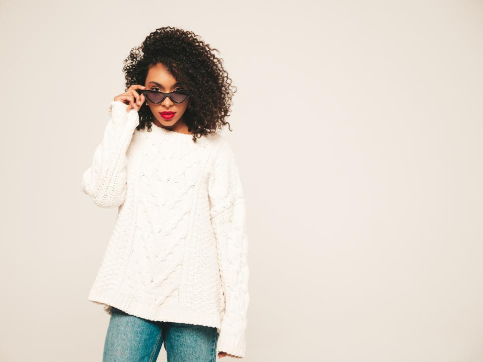 Free Image of Woman in white sweater wearing sunglasses, posing 