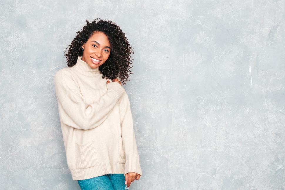 Free Image of Woman in beige turtleneck sweater, smiling confidently 