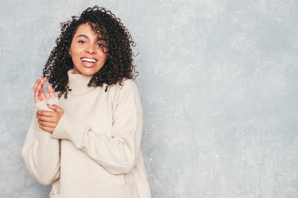 Free Image of Woman in a beige sweater, cheerful and relaxed pose 