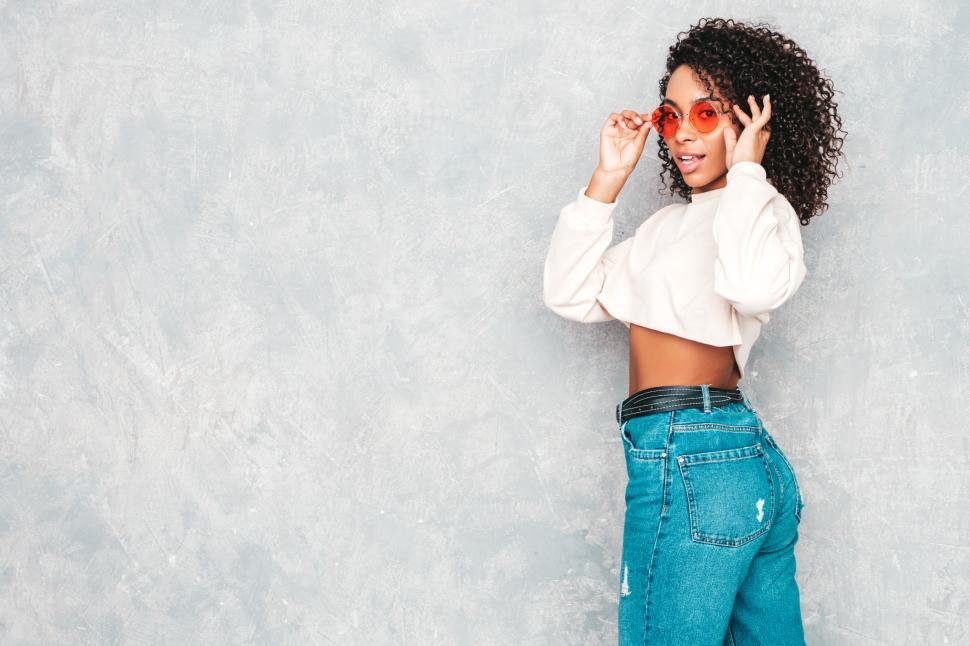 Free Image of Woman in crop top adjusting sunglasses, stylish look 
