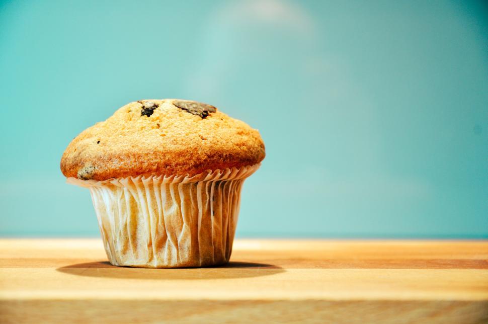 Free Image of Delicious muffin with chocolate chips on wooden table top 