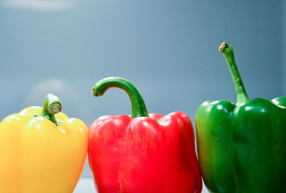 Free Image of Three colorful bell peppers in yellow, red, and green hues 