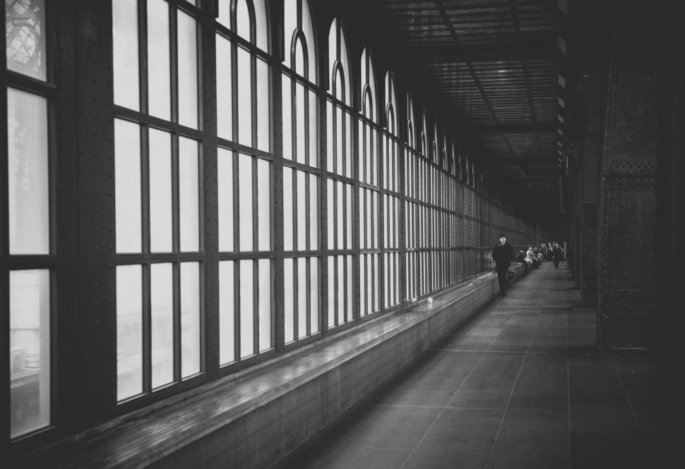 Free Image of Long corridor with arched windows and a lone figure 