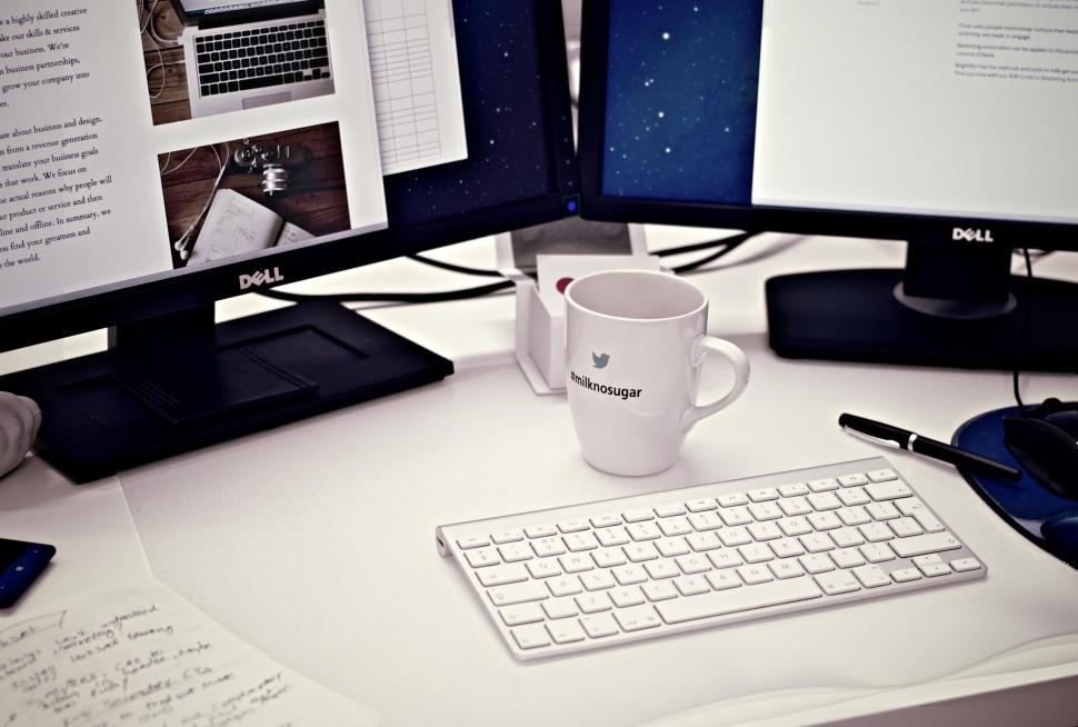 Free Image of Modern office setup with dual screens and coffee mug 