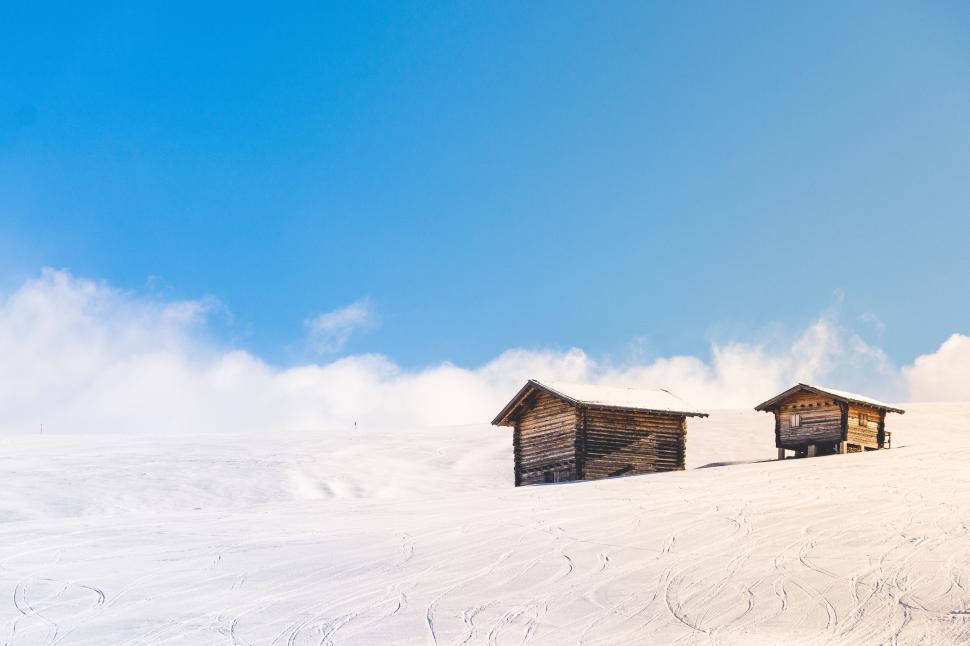 Free Image of Two wooden cabins in a snowy, peaceful mountain area 