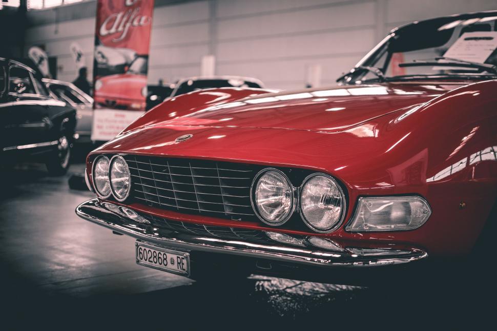 Free Image of Red vintage car front view showing iconic headlights. 