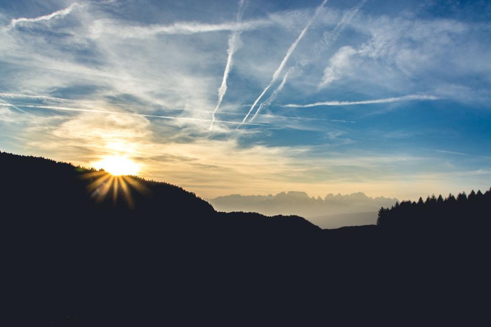 Free Image of Sunrise casting a glow over a misty mountain landscape. 