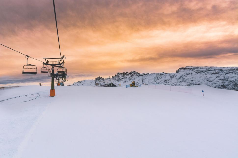 Free Image of Ski lift ascending snowy slope at sunset 