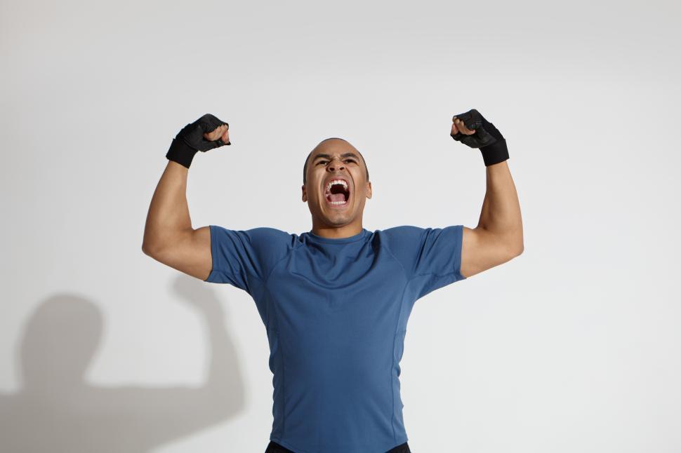 Free Image of Strength, energy, power, sports and determination concept. Picture of determined young dark skinned sportsman roaring in studio, pumping fists and keeping mouth wide opened, showing his muscles 