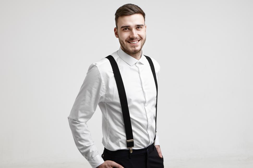 Free Image of Isolated studio portrait of successful handsome young Caucasian businessman with trimmed beard smiling happily at camera after he signed good contract. Business, success, style and fashion concept 