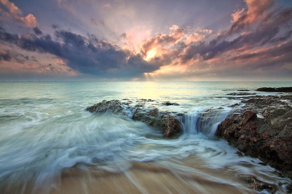 Free Image of Sunset ocean waves cascading over coastal rocks 