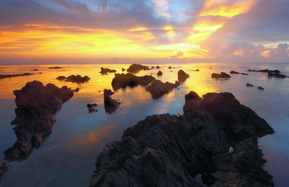 Free Image of Serene rock formations at sunset reflecting golden hues 