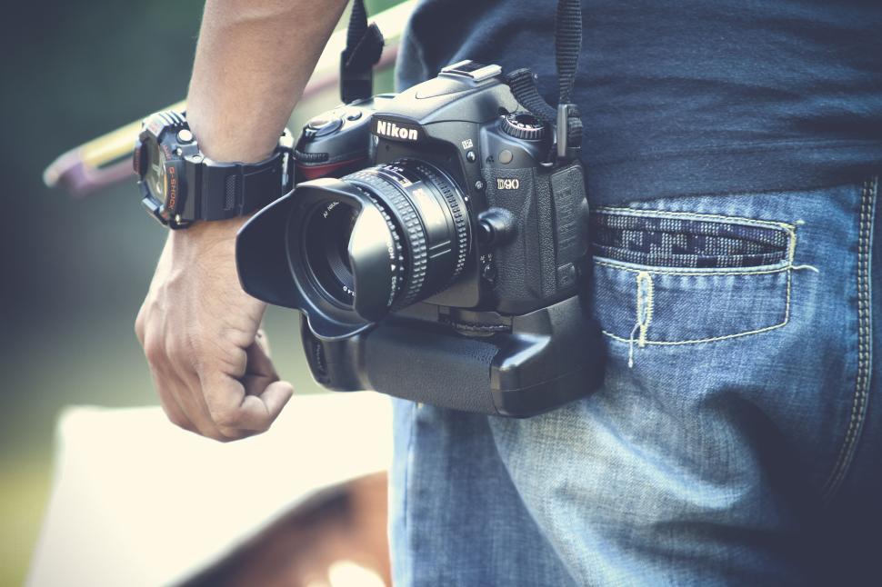Free Image of Close-up of a Nikon D90 camera held by a person. 