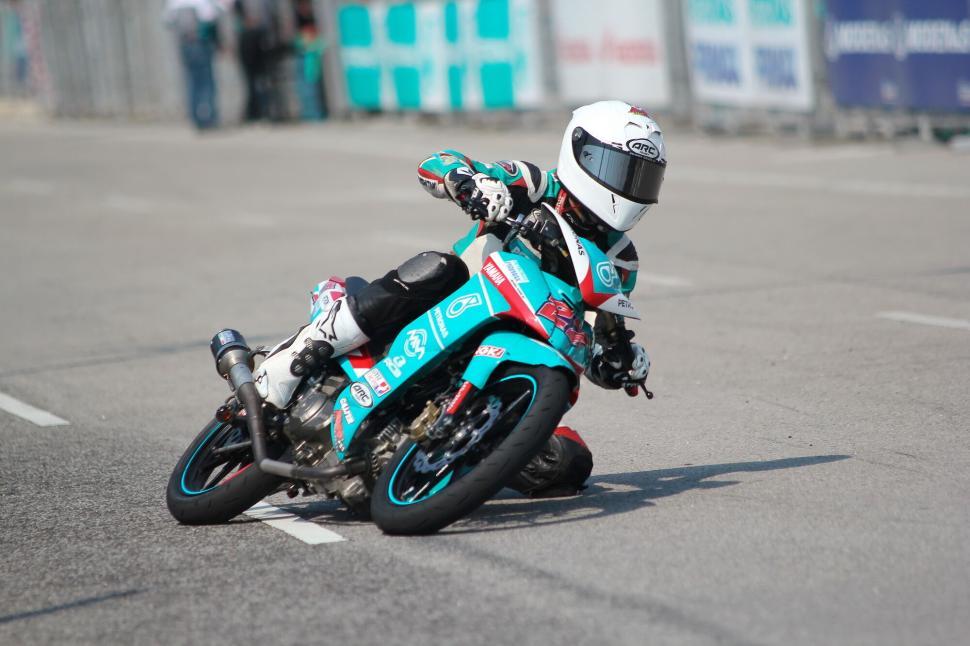 Free Image of Motorcyclist leaning into a turn during a race event. 